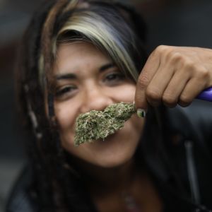 En ung kvinna med en liten mängd marijuana, deltog i en demonstration utanför Högsta domstolen då beslutet om cannabis fattades. 