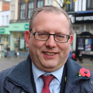 Michael Winstanley hoppas att de konservativa ska lyckas bryta Labours hegemoni i Wigan. Michael Winstanley leder de konservativas regionalorganisation i nordvästra England. På bilden är han iklädd en prydlig ytterrock och slips.