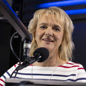 Camilla Andelin bakom mikrofonen i en radiostudio.