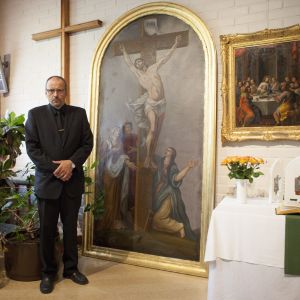 Jouni Heiskanen med altartavlan som han räddade från elden. Jouni Heiskanen står brevid altartavlan som han räddade ur den brinnande kyrkan i Joensuu.