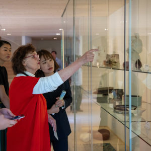 Karin Widnäs visar upp konstverk i ett vitrinskåp i sitt museum Kwum.