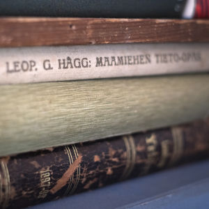 Kolme vanhaa kirjaa pinossa, ylimmän on kirjoittanut Leop. G. Hägg, "Maamiehen tieto-opas."