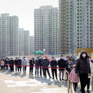 Människor i en kinesiska stad står i en lång kö för att bli testade för coronavirus.  