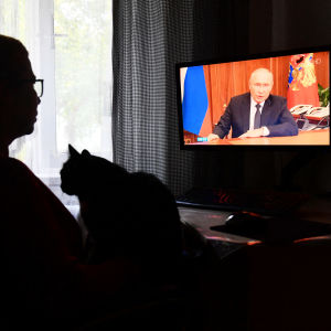 Henkilö katsoo televisiosta Putinin tiedotustilaisuutta.