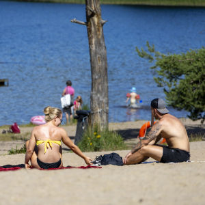 Ihmisiä Viitaniemen uimarannalla viettämässä aurinkoista kesäpäivää.