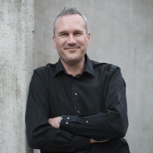 Björn Johnson i halvbild, tittar leende in i kameran.