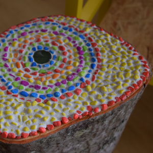  Liimatut moniväriset mosaiikkikivet puupölkyllä