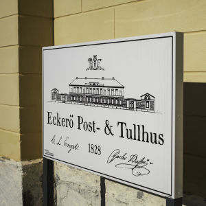 Kyltti, jossa lukee Eckerö post- och tullhus 1828.