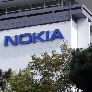 Nokian logo kuvattuna puiden välistä.