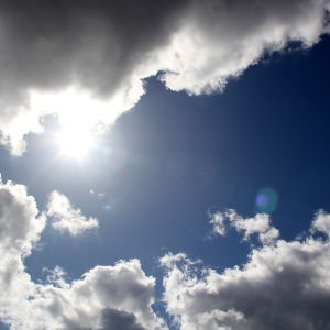 Solen tittar fram bakom moln.