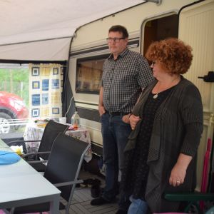 Ett par står i förtältet till en husvagn. 