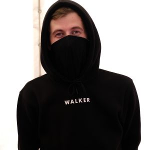 Den norsk-brittiska artisten och DJ:n Alan Walker sitter iklädd svart huvtröja och en rånarluva som täcker nedre delen av ansiktet.