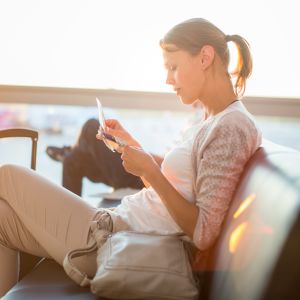 Kvinna som sitter på ett flygfält. 