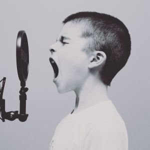 Nuori poika laulaa mikrofoniin