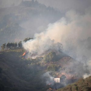 Ett rökmoln svävar ovanför Artenara-området på Gran Canaria då de stora skogsbränderna rasar på ön sommaren 2019.