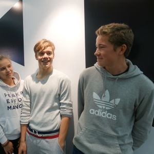 En flicka och två pojkar som besökte bokmässan 2019 i Helsingfors poserar tillsammans