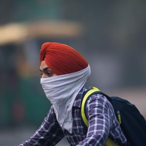 En man som rör sig i trafiken i New Delhi skyddar sig mot luftföroreningar 4.11.2019