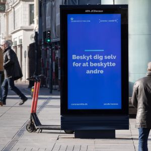Skylt på gata i Köpenhamn uppmanar danskarna att skydda sig själv för att skydda andra.