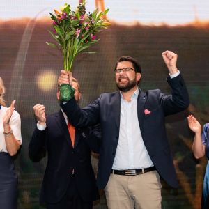 Ruotsidemokraattien Jimmie Åkesson tuulettaa kukkakimppu kädessään.