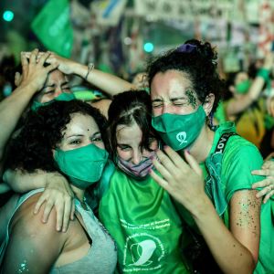 Människor klädda i gröna kläder firar utanför senaten i Argentina efter att abort legaliserats i landet.
