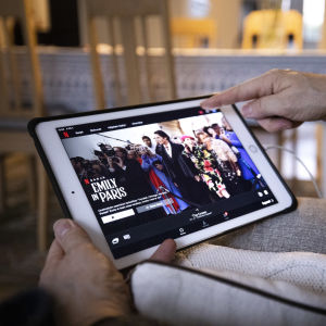 Henkilö selaa Netflixin tarjontaa iPadiltä.