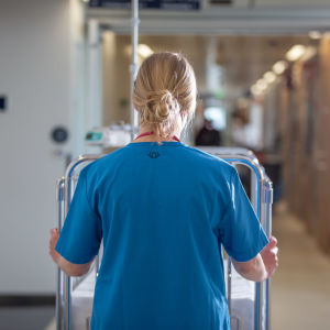 Sjukvårdare går i en sjukhuskorridor. 