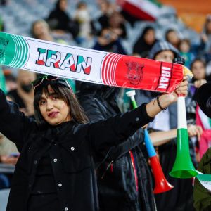 En kvinna hejar på Irans landslag under en fotbollsmatch