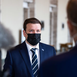 Ville Tavio i munskydd i riksdagen.