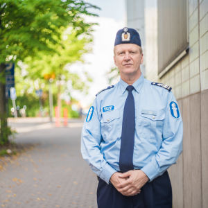 Polisen grep demonstranterna på grund av att de störde trafiken, säger överkommissarie Pekka Höök vid Helsingforspolisen. En polis står framför ett hus och ett träd. Hans min är avslappnad men allvarsam.