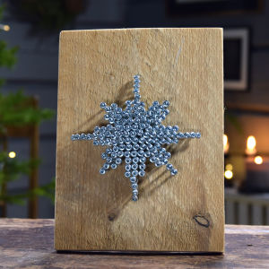 Lankun palasta tehty taulunpohja ja metalliruuveja tähdenmuodossa