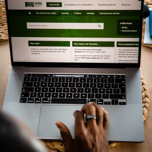 En person sitter framför en laptop med Skatteförvaltningens webbsida öppen.