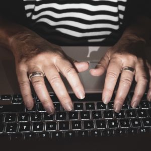 Naisen kädet kannettavalla tietokoneella.