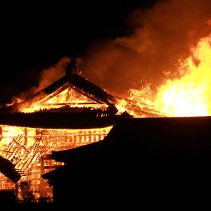 Eldslågor slår upp från det brinnande slottet Shuri på Okinawa