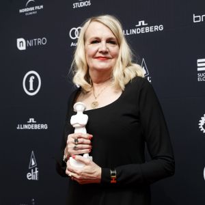Miitta Sorvali fick priset för bästa kvinnliga biroll. En blond kvinna i svart klänning håller i en jussistatyett.