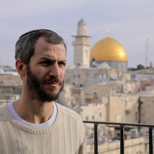 Juutalaisaktivisti Arnon Segal, taustalla vanha kalliomoskeija