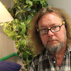 Pedro Viljanen istuu huonekasvin edessä