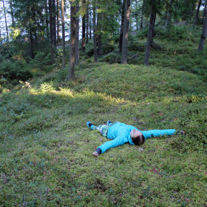Nainen makaa metsässä