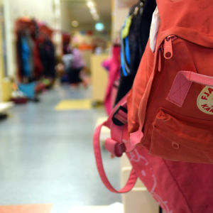 En ryggsäck hänger på en knagg i en skolkorridor.