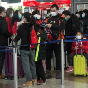 På bilden syns resenärer som köar till flyg på väg till Shangai på en flygplats i Prag.