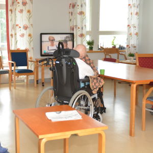 En person sitter i en rullstol på en bäddavdelning.