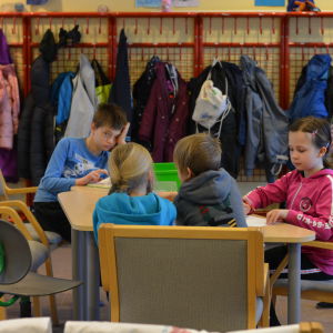 Flera barn sitter runt ett bord.