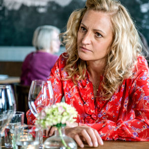 Ella berättar för sin vän att hon skapat en profil på en dejtingsida. Karaktären Ella i röd skjorta i en restaurang.