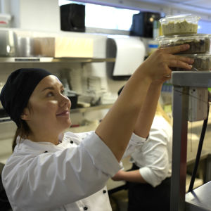 Linda Långsjö säger att man inte ska vara rädd för att göra stora vegetariska portioner. Kock radar mataskar på hylla.