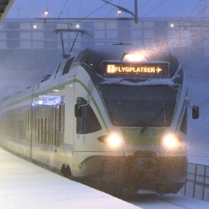 Ett närtåg i snöyra. Tåget är på väg till Helsingfors-Vanda flygplats.