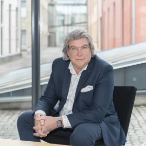 Sen får vi göra bokslut och se hur väl vi lyckades, säger Mikael Lindfelt om årets antagning till ÅA som i år avgörs långt mer än planerat på basis av studentbetyg. Mikael Lindfelt prorektor vid Åbo Akademi sitter i fåtölj med händerna ihop i famnen.