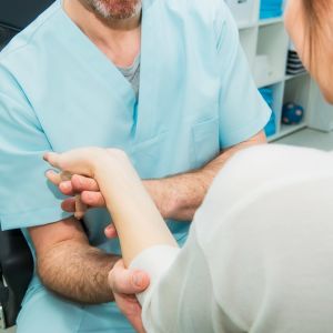 en läkare eller skötare undersöker en patients arm