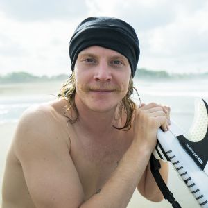 Kuvassa Away - Bali -sarjan Jeppe poseeraa surffilaudan kanssa.