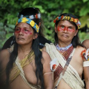 Tre kvinnor klädda i Waoranifolkets kläder och ansiktsmålningar.