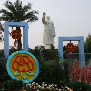Staty föreställande Mao Zedong omgiven av palmer.