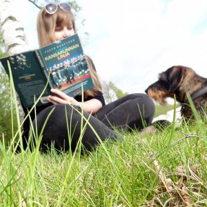 1001 elämää ja yksi pieni elämä -blogin kirjoittaja lukee Paavo Haavikkoa puistossa.